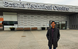 Young man in front of the Scania Technical Center building
