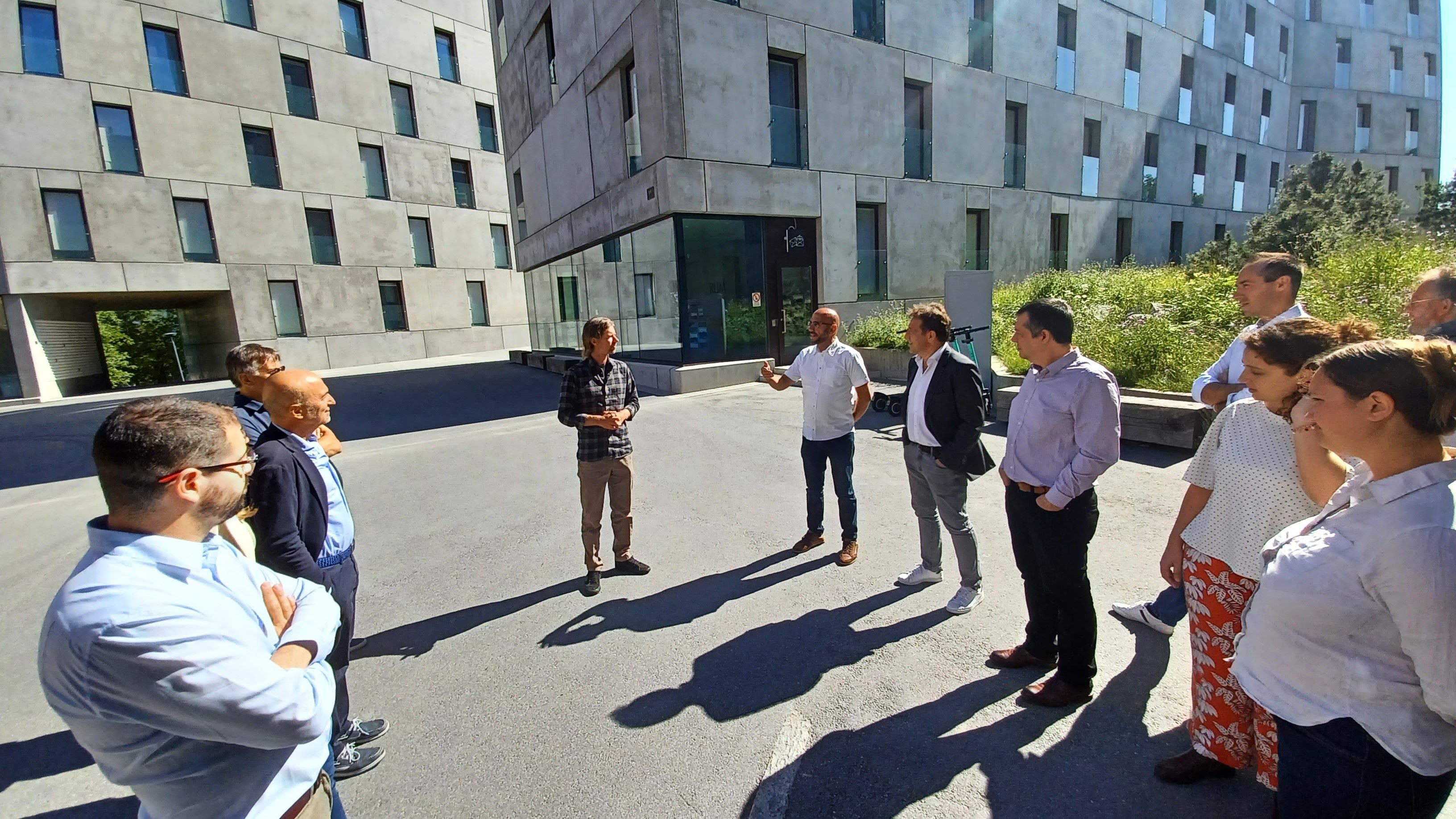 A group of researchers talking in front of modern buildings